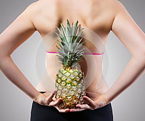 Unrecognizable fit woman with pineapple