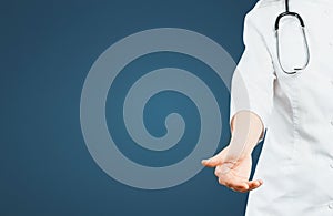 Unrecognizable Friendly Female Doctor Reaches Out To Patient On Blue Background With Copy-space