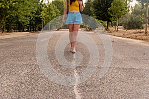 Unrecognizable girl walking in the middle of the street.