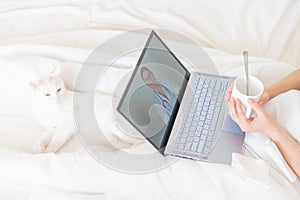 Unrecognizable girl watching a video with medical advice on a laptop. A woman conducts an online conversation with a