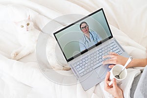 Unrecognizable girl watching a video with medical advice on a laptop. A woman conducts an online conversation with a