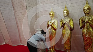 Unrecognizable girl worships sacred golden statue