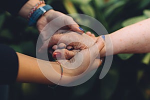 Unrecognizable grandmother and her granddaughter holding hand with love. Grandparents protection concept