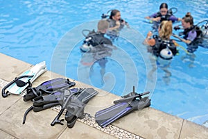 Unrecognizable group of people learn to scuba dive in a pool