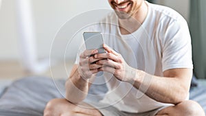 Unrecognizable Guy Using Phone With Mobile Application In Bedroom, Cropped