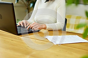 Unrecognizable hand Freelancer woman working with laptop on the table at home