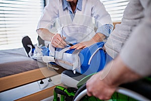 Unrecognizable healthcare worker and paralysed senior patient in hospital. photo