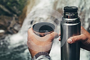 Unrecognizable Hiker Man Pours Tea Or Coffee From Thermos Hiking Travel Vacation Concept