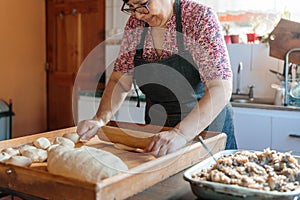 Unrecognizable Hispanic Woman Kneading Dough with Hands and Rolling Pin in Her Countryside Kitchen photo