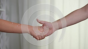 Unrecognizable ill woman and healthy man shaking hands in slow motion at white background. Young sick Caucasian lady