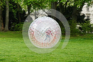 Unrecognizable kid zorbing in park