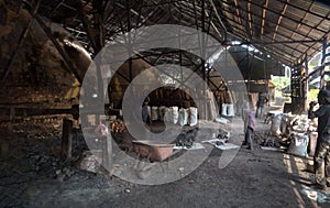 unrecognizable laborers working indoor around the kiln factory.