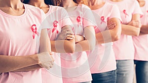 Unrecognizable Ladies In Cancer Awareness T-Shirts Posing Over White Background