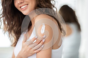Unrecognizable Lady Applying Cream On Shoulder Moisturizing Skin In Bathroom