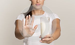 Unrecognizable Lady Holding Milk Gesturing No To Glass, Gray Background