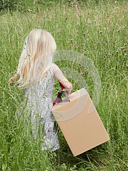 unrecognizable little girl carrying a large cardboard box with ribbon