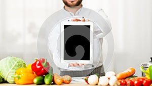 Unrecognizable Male Chef Showing Blank Tablet Screen Standing In Kitchen