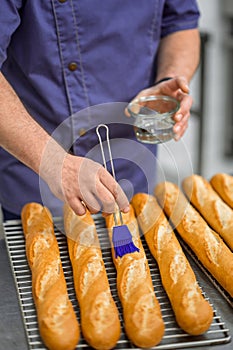 Unrecognizable man baker baking and selling tasty breads