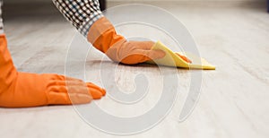 Unrecognizable man cleaning floor with rag