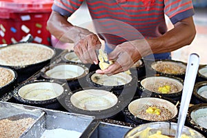 Unrecognizable man is cooking traditional Malaysian street food apam balik. Street market in Georgetown, Malaysia