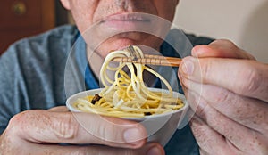 Unrecognizable man eating spaghetti with crickets