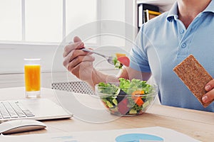 Unrecognizable man has healthy business lunch in modern office i