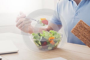 Unrecognizable man has healthy business lunch in modern office interior