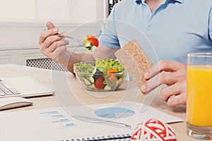 Unrecognizable man has healthy business lunch in modern office interior