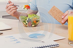 Unrecognizable man has healthy business lunch in modern office interior