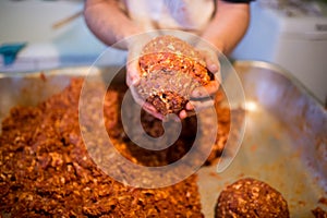 Unrecognizable man holding meat ball in his hands, close up.