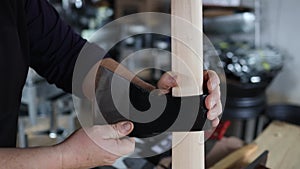 unrecognizable man making a handmade ax with wooden stick, in his workshop.