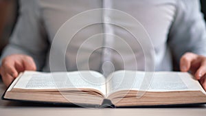 Unrecognizable man open vintage paper book searching educational information on library desk closeup