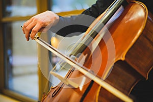 Unrecognizable man playing the cello in public