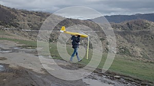 An unrecognizable man raises his toy plane