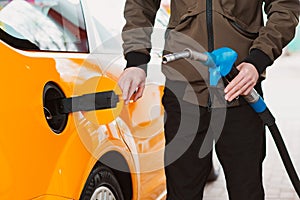 Unrecognizable man refueling car from gas station filling benzine gasoline fuel in car at gas station. Petrol high