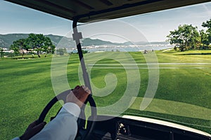 Unrecognizable Man Rides Golf Cart On Green Golf Course