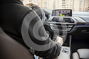 Unrecognizable manis parking back using the surround camera parking assist with parking radar on the touchscreen display