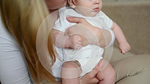 Unrecognizable mother holds, hugs and rocks her newborn baby. Child care, maternity leave, childhood. Children's Day