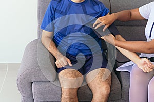 Unrecognizable nurse checking a man`s blood pressure