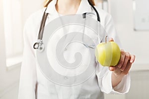 Unrecognizable nutritionist woman with green apple