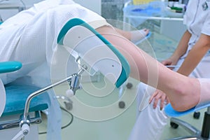 Unrecognizable patient woman in a gynecological chair in clinic, side view.