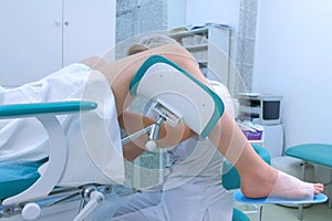 Unrecognizable patient woman in a gynecological chair in clinic, side view.