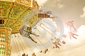 Unrecognizable people on flying swing attraction