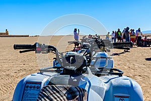 Unrecognizable people near quad bikes during safari trip in Arabian desert not far from the Hurghada city, Egypt