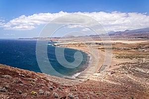 Unrecognizable people swimming, sunbathing and walking on La Tejita beach in Granadilla de Abona municipality, El Medano, Tenerife photo