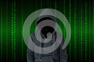 Unrecognizable person in a black hoodie with a green matrix of numbers in background