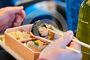 Unrecognizable person eating Japanese Eki Bento on a Shinkansen Train in Japan.