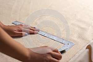 Unrecognizable Person is measuring fabric using rules