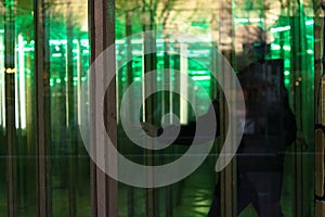 unrecognizable person seeking the way out in a house of mirrors, a glass maze on an amusement funfair, copy space