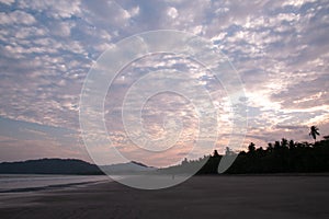 Unrecognizable person walking alone in a sunset on a beach in Costa Rica photo